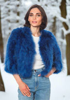 A woman wearing a blue marabou feather bolero jacket with 3/4 length sleeves and a crew neck.