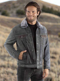 A man wearing a gray suede leather jean jacket with a button front closure, two side pockets, two chest pockets, and a faux sherpa lining and collar.