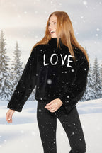 Woman wearing a black sweater with 'LOVE' printed on it